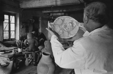 Marc Chagall tient à deux mains une céramique en forme d'oiseau.